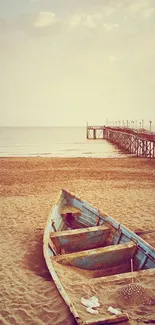 Old wooden boat on a sandy beach with a rustic pier extending into the sea.