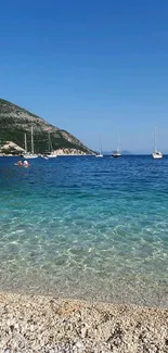 Mobile wallpaper of a serene beach with blue seas and sailboats.