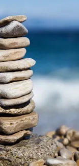 Stack of stones on a tranquil beach with the ocean in the background.