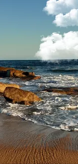 Scenic beach sunset with ocean waves and rocky shoreline.