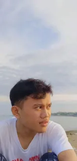 Person enjoys serene beachside view under a vast sky.