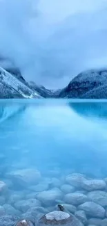 Serene blue lake amidst snowy mountains.