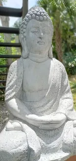 Tranquil Buddha statue in lush garden setting.