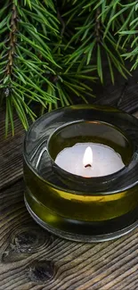 Candle with pine branches on wooden table wallpaper.