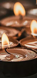 Close-up of glowing candle flames in a serene setting.