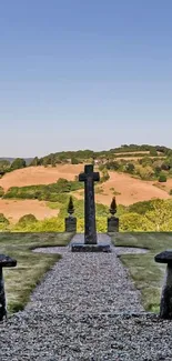 Serene countryside landscape wallpaper with trees and cross.