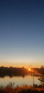 Tranquil dusk view with lake and crescent moon.