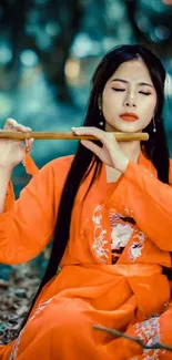 Woman in orange dress playing flute in a serene forest.