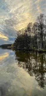 Tranquil forest reflected in a calm lake at sunrise.