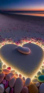 Heart shape in sand surrounded by colorful stones at beach during sunset.