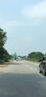 Serene highway surrounded by greenery and clear sky.