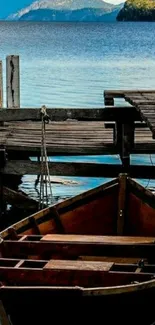 Serene lake with a wooden boat by a rustic pier and distant mountains.