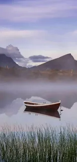 Tranquil boat on misty lake with mountains.