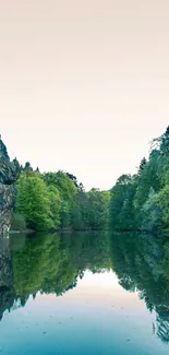 Tranquil lake surrounded by green forest and rocks.