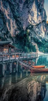 Scenic view of lake, mountains, and cabin at sunset.