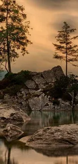 Tranquil lake with rocky terrain and trees in misty mountains.