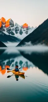 Kayaker on a serene lake with mountain reflections at sunrise.