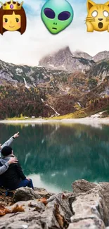 Couple by lake with mountain backdrop and emojis in sky.