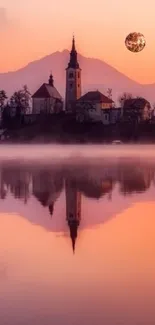 Lake reflecting a pink-orange sunset with a village and moon.