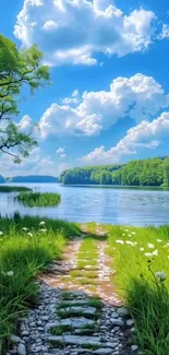 Tranquil lake with green pathway and blue sky.