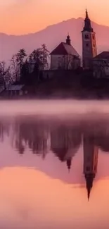 Serene sunset with church reflection on a tranquil lake.