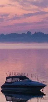 Boat on tranquil lake during purple sunset.