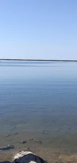 Tranquil blue lake with clear sky wallpaper scene.