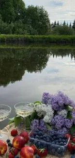 Picnic by serene lake with fruits and flowers.