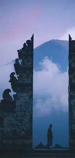 Tranquil mountain scene with traditional gate and misty backdrop.