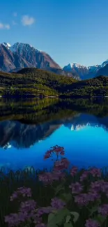 Mountain landscape with sky blue lake reflection and purple flowers.