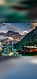 Cozy cabin by tranquil mountain lake at sunset.