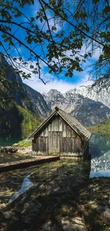 Rustic cabin by a tranquil mountain lake with lush greenery.