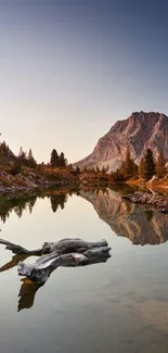 Serene mountain lake reflecting a sunset-lit peak, with tranquil surroundings.