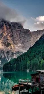 Beautiful mountain and lake scenery with a wooden cabin on the shore.