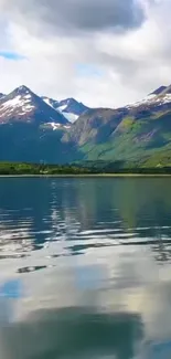 Serene lake with mountain backdrop and cloudy sky.