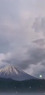 Majestic mountain under a cloudy sky in serene landscape.