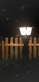 Glowing lantern by a fence at night, creating a tranquil atmosphere.