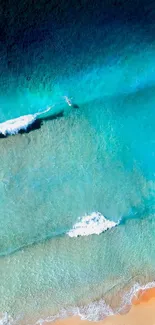 Aerial view of ocean waves and sandy beach with turquoise water.