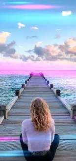 Person seated on dock overlooking tranquil ocean with cloudy sky.