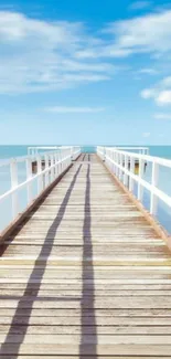 Wooden pier extending into the calm ocean under a clear blue sky.