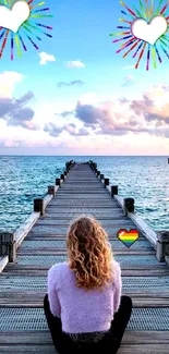 Woman sitting on a pier with ocean view and colorful sky.