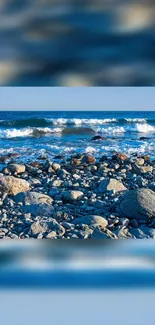 Rocky beach with ocean waves crashing under a blue sky.