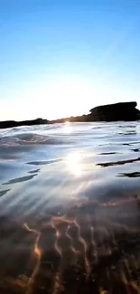 Tranquil ocean sunset with gentle waves reflecting golden sunlight.