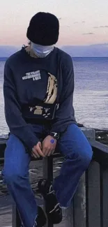 Person sitting quietly with ocean backdrop.