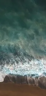 Aerial view of serene ocean waves crashing onto a sandy beach.