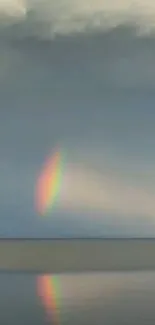 Tranquil phone wallpaper with rainbow reflection on calm waters.