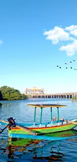 A peaceful river with a colorful boat under a blue sky with birds flying.