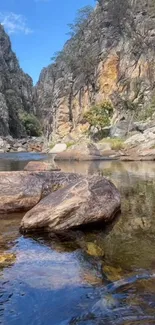 Serene river flowing through a canyon with rocky cliffs.