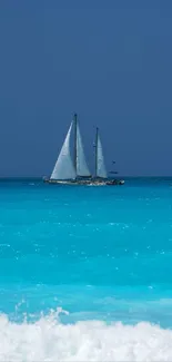 Sailboat on a turquoise sea under a clear blue sky.