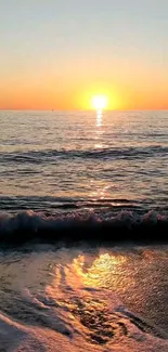 Stunning sunset over a tranquil ocean with gentle waves crashing on the shore.